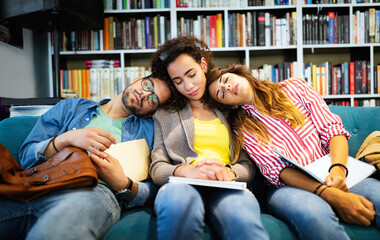 Wall Mural - College, study, university and education concept. Group of tired students learning in library