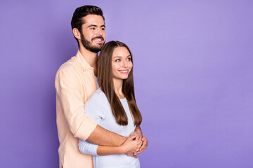 Sticker - Photo of happy young married couple stand look dream empty space hug isolated on purple color background