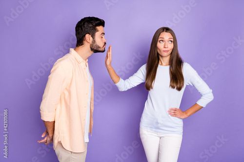 Photo of brunette people man send air kiss woman refuse hand waist ignore isolated on purple color background