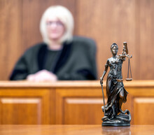 Statue Of Justice And Judge In Robe At Background