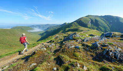 Sticker - A female hiker and their dog walking, hiking along a mountain path towards the summit of Ben Lawers from the top of Beinn Ghlas in the Scottish Highlands, UK landscape.