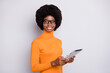 Photo portrait of afro american woman holding tablet in two hands isolated on clear grey colored background