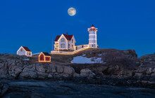 Fantastic Full Moon Rise Over A Lighthouse