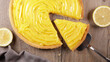 lemon tart and slice on wood background