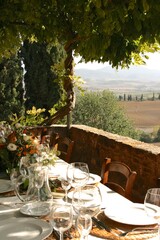 table set for al fresco dinner on the terrace. tuscany, italy