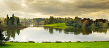 Tranquil Sunset  In The Blenheim Palace Lake And Vanbrugh Bridge In Oxfordshire, England
