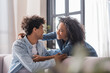 © LIGHTFIELD STUDIOS - Smiling african american couple hugging at home
