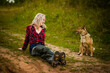 blonde girl in a red shirt in nature with a dog, selective focus