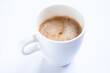 © Henk Vrieselaar - Cup of coffee with handle, isolated on a white table. Seen obliquely from above. Focus on the froth of the coffee. CUP WITHOUT SAUCER