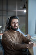 © AnnaStills - Young bearded man in headphones working as a operator in call center