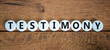 Testimony symbol. White circles with the word 'testimony'. Beautiful wooden background. Business, testimony concept. Copy space.