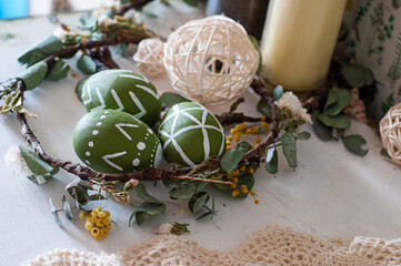 Festive Easter decor. A wreath of flowers, painted eggs. Vintage