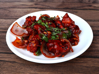 Wall Mural - Chilli Chicken is an Indian Chinese starter served over a wooden rustic background. selective focus