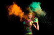 Beautiful young woman with dry colorful powder holi exploding. Holi festival color