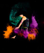 A young woman makes a high jump with explosion of dry colorful holi powder. Holi festival india