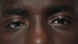 Extreme closeup surprised african american male eyes looking at camera. 