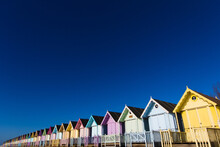 Parade Of Colourful Beach Huts On Mersea Island In Essex