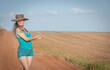 © Alex R. Brondani - Brazilian woman wearing a hat showing a planting field.