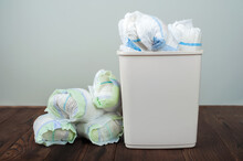 Diapers Waste, Dirty Diapers In Garbage Pail Disposing Of Used Baby Nappies. Environmental Impact Of Disposable Diapers. Pollution Of The Environment, Soil And Water