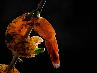 Wall Mural - Grilled shrimp closeup on a black background, seafood and grilling cooking.Black background, banner