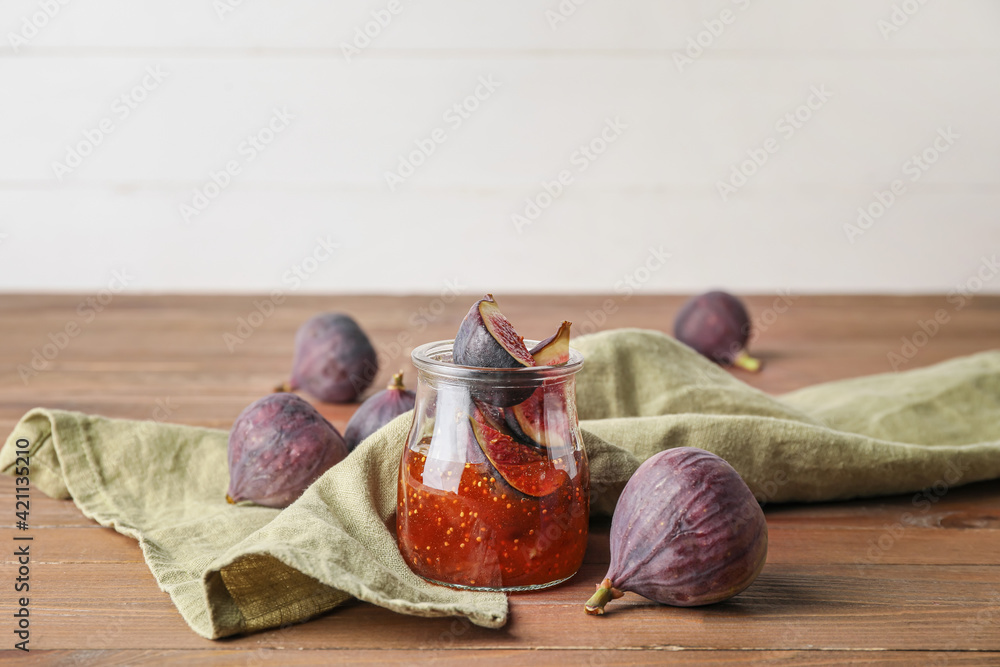 Jar of sweet fig jam on wooden table