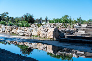 Poster - view of gardens with reflections into a puddle