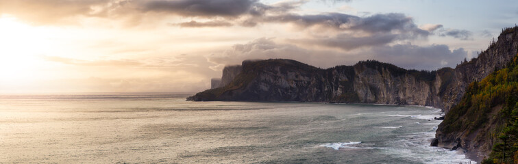 Beautiful panoramic Canadian landscape of a rocky coastline on the East Coast. Dramatic Sunrise Sky Art Render. Taken in Forillon National Park, near Gaspe, Quebec, Canada.