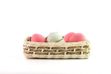 Pink, White Easter Eggs In Wooden Basket On White Background.