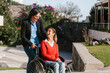 © Marcos - Happy young latin woman in wheelchair and her friend having fun outdoors in Mexico