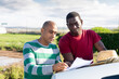 © JackF - Farmer and worker signing some papers while standing near car on farm on sunny spring day.