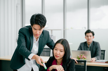 Wall Mural - Group of young business people sit at their desks with smiling colleagues together in the office.  Meeting business people  planning concept, laptop meeting ideas. Concentrate on work. LGBT teamwork.