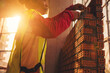 © Panumas - Bricklayer construction worker installing red brick masonry on exterior wall at outdoors construction site