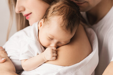 A loving mother carries her newborn baby at home. portrait of a happy mother holding a sleeping baby in her arms. Mother hugs her little 4-month-old daughter