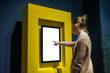 © zyabich - Woman hand using vertical white blank interactive touchscreen display of electronic multimedia kiosk in dark room - scrolling and touching. Mock up, copyspace, template and technology concept