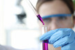 © megaflopp - Researcher drips purple liquid from pipette into test tube