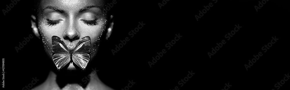 Fashion model woman in bright sparkles and lights posing in studio. Portrait of beautiful sexy woman with butterfly. Art design glitter glowing make up. Black and white photography - obrazy, fototapety, plakaty 