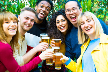 Wall Mural - Group of multicultural friends drinking and toasting beer at brewery bar restaurant - Happy people having fun at rooftop home party - Vivid color filter