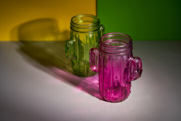  Yellow and pink cactus-shaped glasses on a multi-colored background