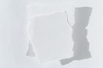 Two pieces of torn white paper on a light background with a copy of the text space