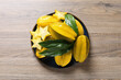 Delicious carambola fruits on wooden table, top view