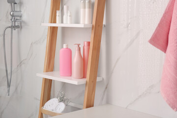 Poster - Soft towels and different toiletries on decorative ladder in bathroom. Interior design