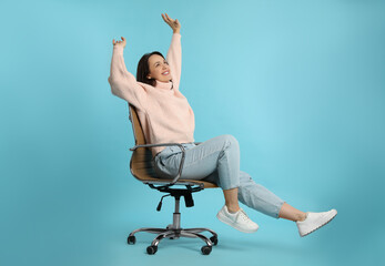 Mature woman riding in comfortable office chair on turquoise background