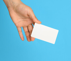 female hand holding a white black business card, blue background