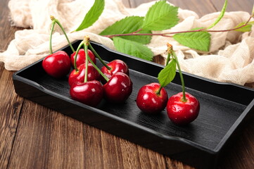 Wall Mural - Fresh cherry fruit and leaf on wooden table.