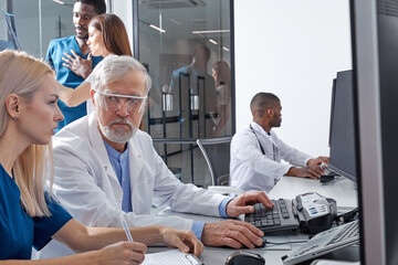 In Control Room Senior Doctor and Radiologist Discuss Diagnosis Using Monitors Showing Brain Scans Results