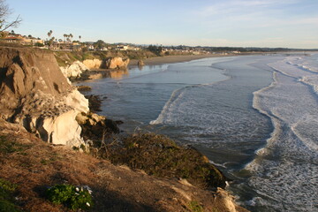 California Coast, Pismo Beach, From a Cliff with the Sun Low Showing the Power of the Waves Eroding the Rock Shore as the Waves Erode the Rock