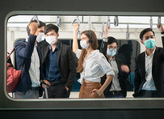 View through the window of passengers with face protection masks inside city trains from a platform of the subway station. Traveling concept. Coronavirus pandemic. .