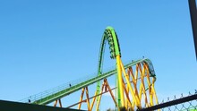 SLOW MOTION: Riddler's Revenge Roller Coaster In Six Flags Magic Mountain Cresting The Loop On A Sunny Day.
