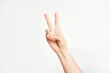 © lara-sh - Woman's hand gesturing peace sign or victory on light grey background