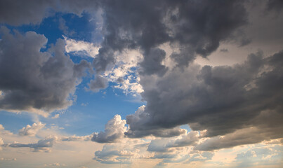 Wall Mural - dramatic dark sky with rays and white clouds at sunset